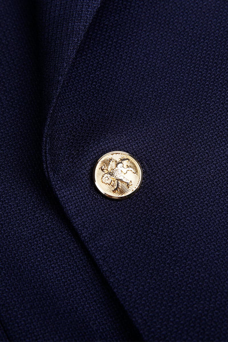 Gold crest button on navy double-breasted jacket