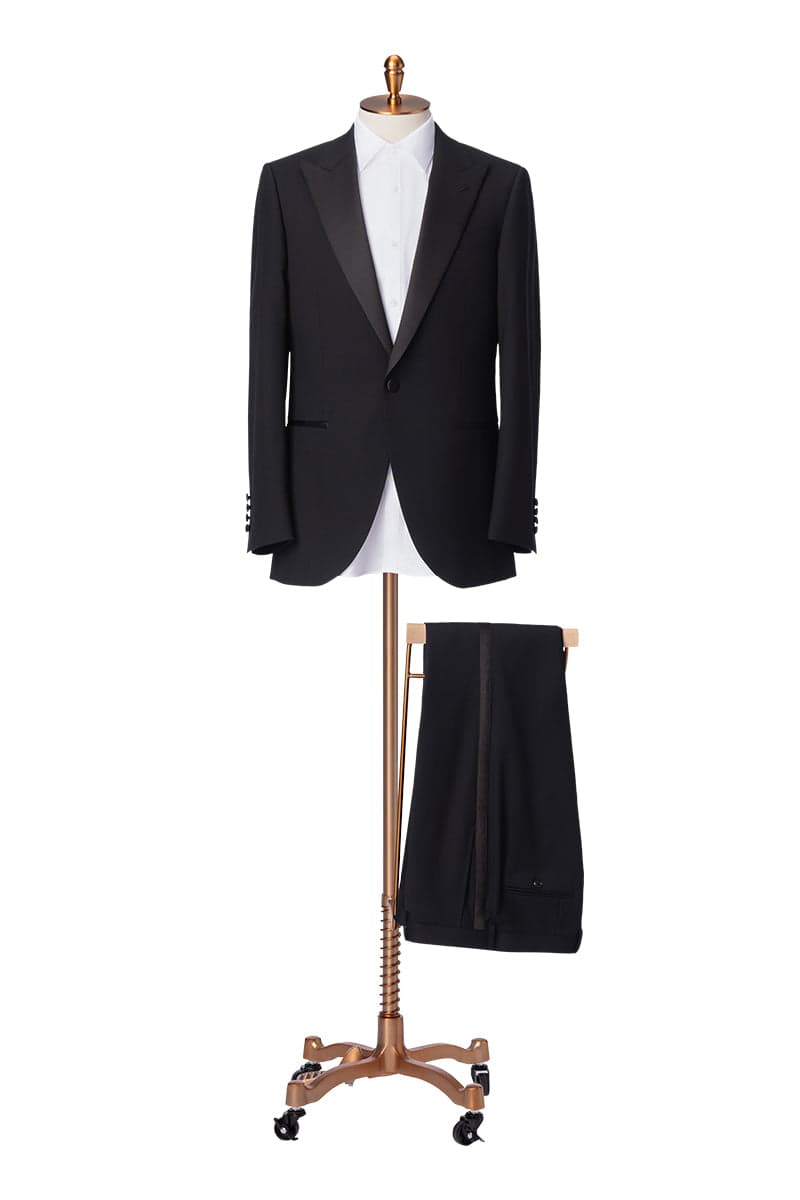 Sam Cole at work · pinning a black tuxedo on the form